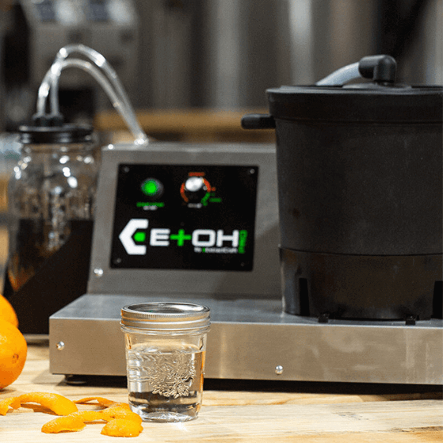 ExtractCraft ETOH Pro Rev2 Oil Extractor with oranges on table, perfect for preserving botanicals' natural benefits in small businesses.