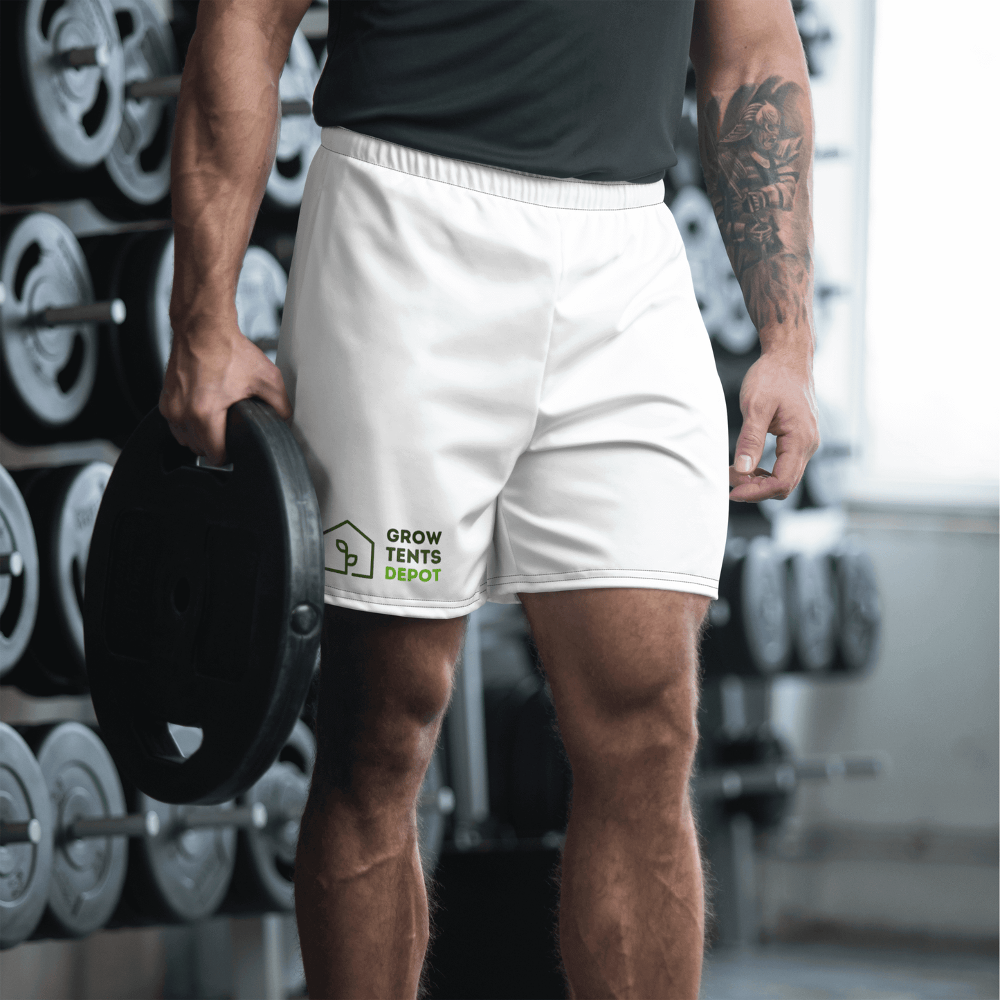 Man wearing Grow Tents Depot men's athletic shorts holding a weight in a gym setting.